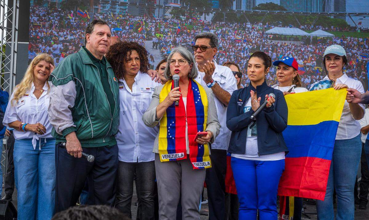 Miami-Dade County Mayor Daniella Levine Cava speaks to the crowd as Miami City Commissioner Joe Carollo, left and Doral Mayor Christi Fraga, right, listen along with Venezuelan community leaders and activists.