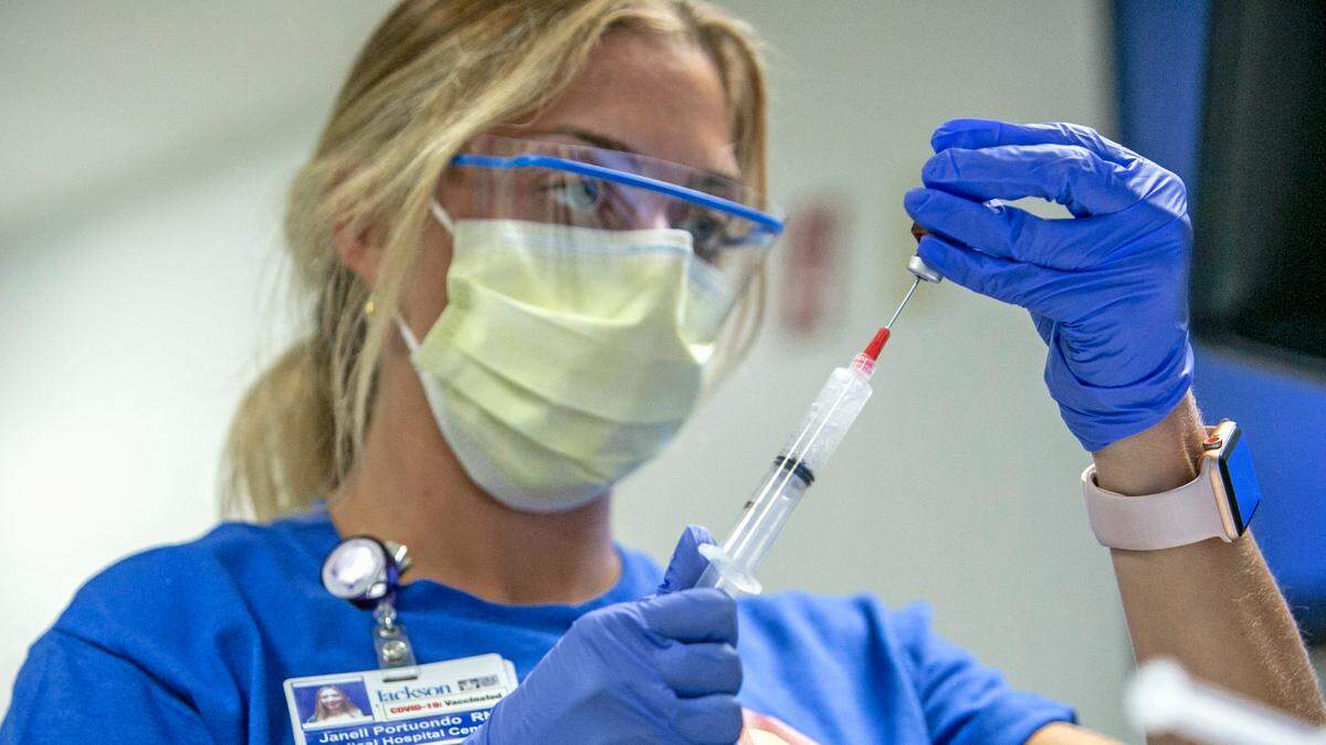 A nurse prepares medication in August 2021 for a COVID-19 patient in the Medical Intensive Care Unit at Jackson Memorial Hospital in Miami. The high costs of treating COVID patients, coupled with lower payroll taxes that fund Medicare, have strained Medicare’s Part A trust fund.