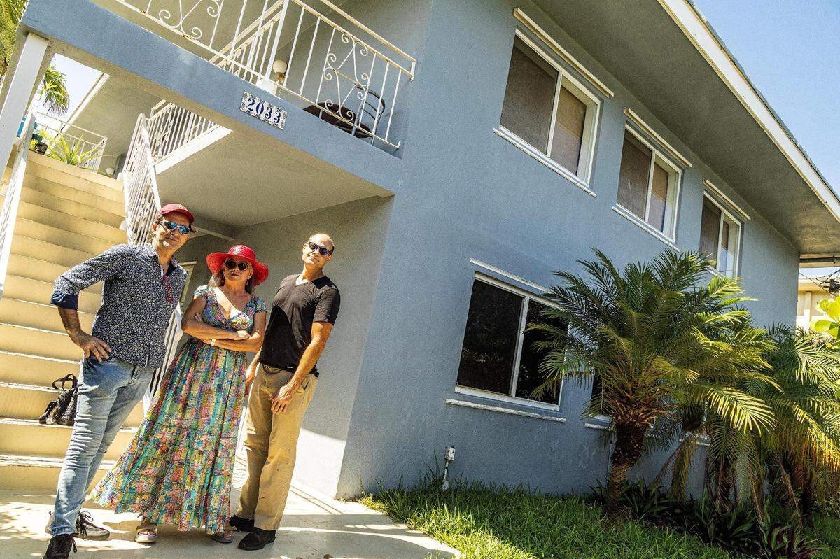 Los habitantes de Miami Beach, de izquierda a derecha, Daniel Fiorda, Laura Inés Cobos y Brian Trevisa, de pie delante de su edificio en 2033 Calais Drive, donde un inversionista compró la mayoría de las unidades y ahora enfrentan enormes aumentos de cuotas, el sábado 10 de junio de 2023.