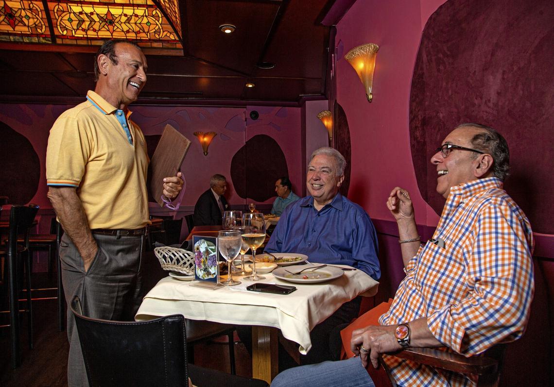 Nino Pernetti, owner of Caffe Abbracci, celebrates 30 years in the restaurant business in Coral Gables. Here, Pernetti, at left, visits with Rolando Guerreiro, at center, and Lombardo Perez, at right, while they dine at the restaurant on Tuesday, July 16, 2019.