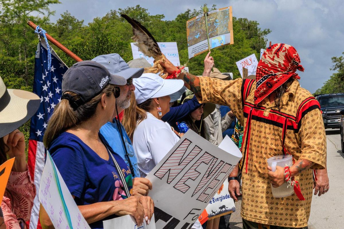 A tribe member blesses protesters outside of the Dade-Collier Training and Transition Airport during the “Stop Alligator Alcatraz” protest in opposition to the construction of a massive detention facility for undocumented immigrants on the site, which is in the middle of the Florida Everglades, in Ochopee, Florida, on Saturday June 28, 2025.