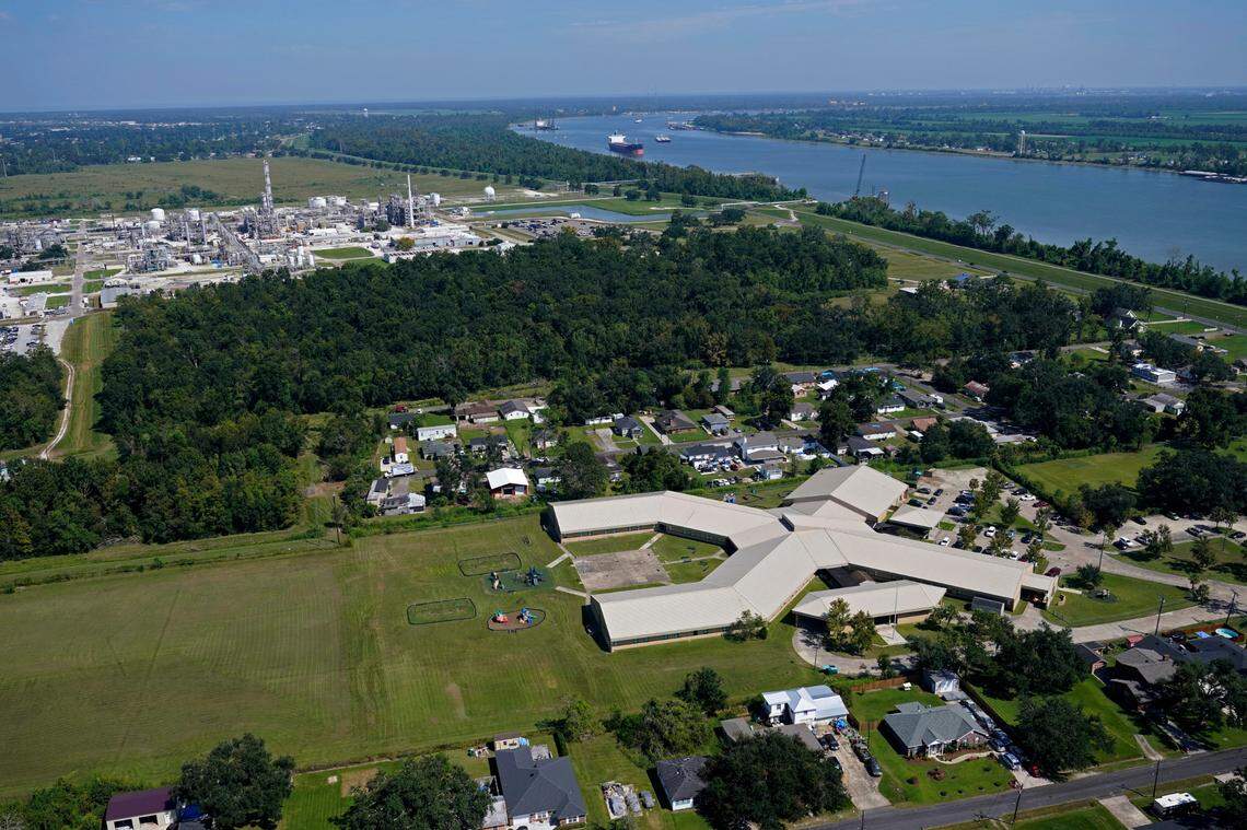 The Fifth Ward Elementary School and residential neighborhoods sit near the Denka Performance Elastomer Plant, back left, in Reserve, La., Friday, Sept. 23, 2022. Less than a half mile away from the elementary school the plant, which is under scrutiny from federal officials, makes synthetic rubber, emitting chloroprene, listed as a carcinogen in California, and a likely one by the Environmental Protection Agency. (AP Photo/Gerald Herbert)