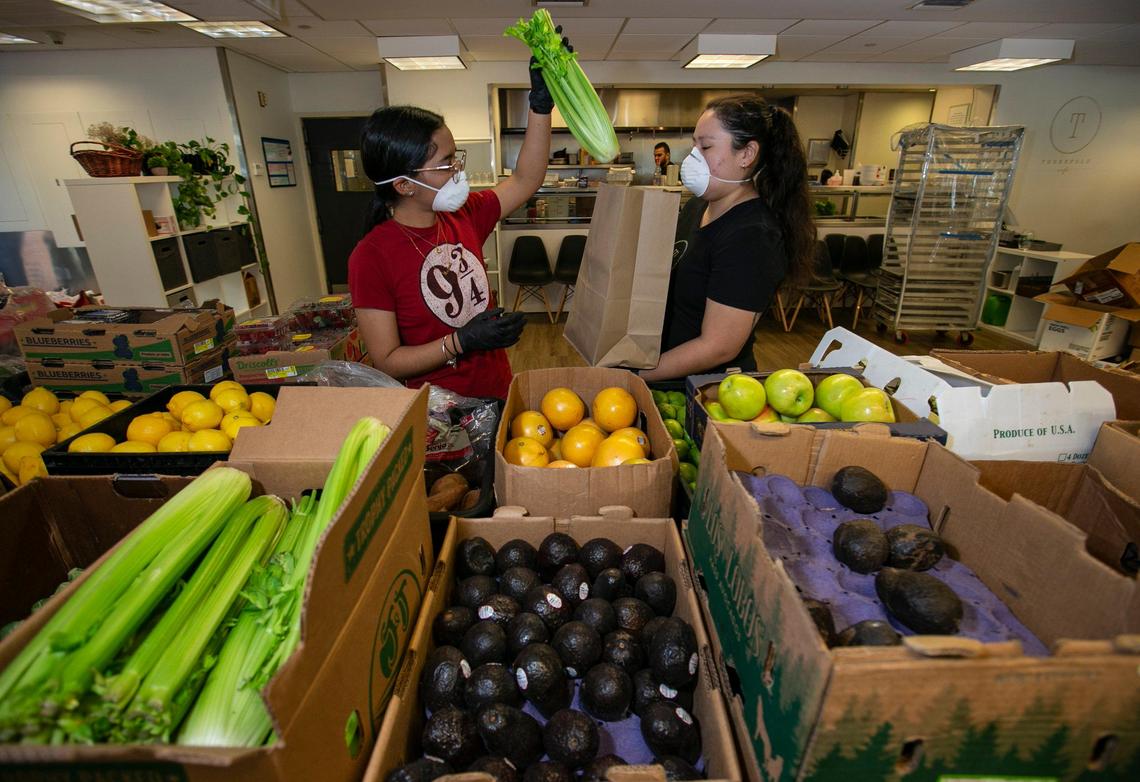 Andrea Franco, left, and Ruth Aguilera, package groceries at Threefold Cafe for customers. Due to COVID-19, many restaurants have closed or been limited to pick up or delivery. But several are turning to selling groceries, including eggs, that would be otherwise stuck up the supply chain at farms, dairies and ranches.