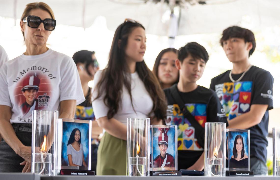 Candles are lit in honor of Helena Ramsay, Alexander Schachter and Carmen Schentrup during the ‘Forever in Our Hearts’ commemoration event outside of the Eagles’ Haven Wellness Center on Friday, Feb. 14, 2025, in Coral Springs, Fla. The event aims to honor the 17 lives lost during the Marjory Stoneman Douglas High School shooting in 2018 and their families.
