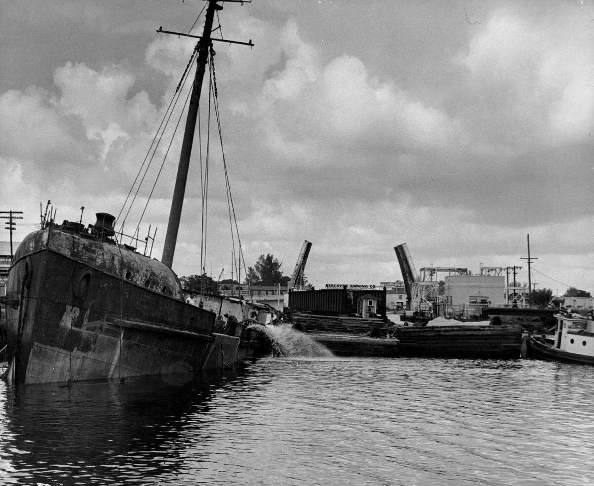 Pumps and barges are used to try to keep a boat from blocking a Miami River channel