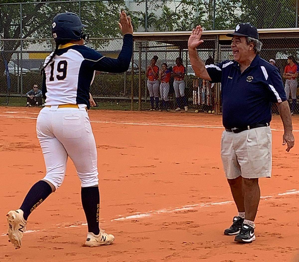 Coral Park Senior High varsity softball coach Horacio Sierra congratulates one of his players. He retired this summer, after joining the school in 2003.