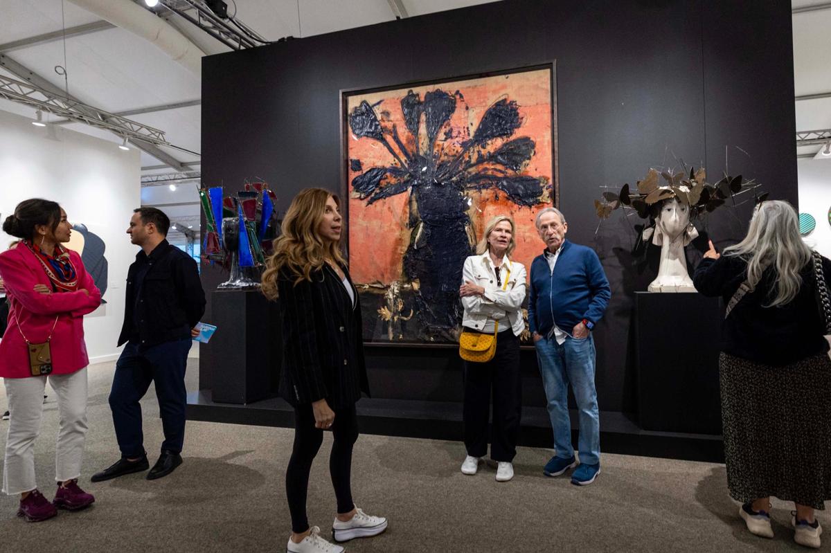 Guests stand in front of ‘Les Tulipes noires’ by Manolo Valdes during Art Miami at One Herald Plaza on Tuesday, Dec. 3, 2024, in Miami, Fla.