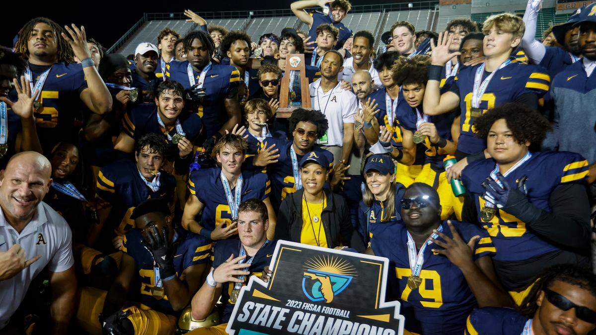 St. Thomas Aquinas coach Roger Harriott holds the state championship trophy after defeating the Homestead Broncos in the Class 3M state championships at Bragg Memorial Stadium in Tallahassee, Florida on Saturday, December 9, 2023.