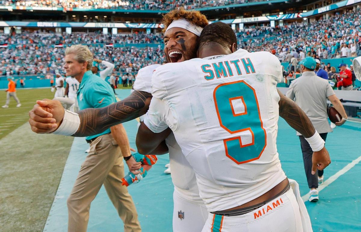 Miami Dolphins quarterback Tua Tagovailoa (1) and tight end Jonnu Smith (9) celebrate the win in overtime against the New York Jets in their NFL football game at the Hard Rock Stadium in Miami Gardens, Florida on Sunday, December 8, 2024.