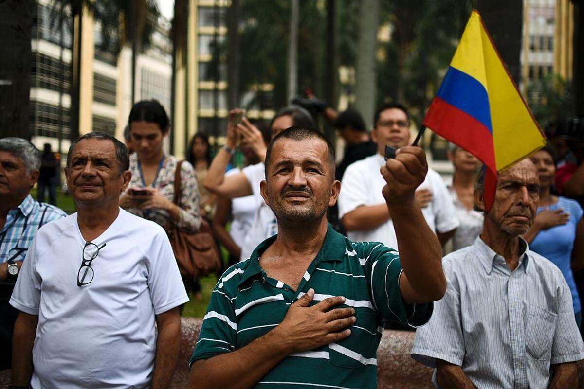 In June 2016, people sing the national anthem in Cali, Colombia, as they celebrate the peace agreement between the government and the FARC leftist guerrilla group.