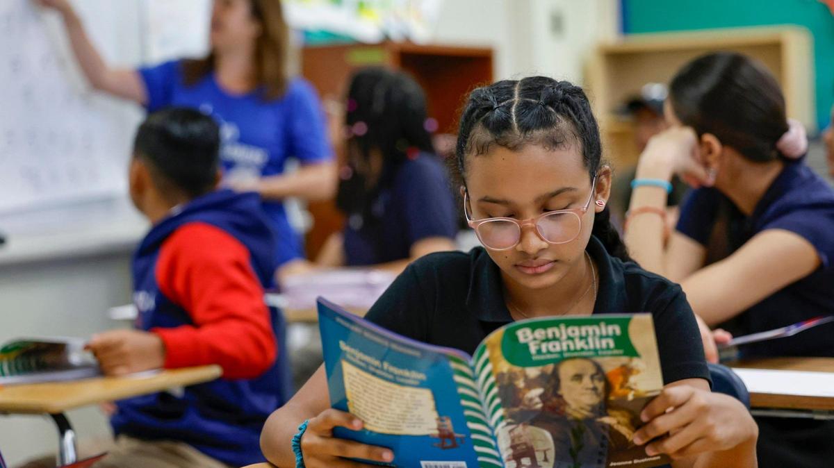 Camila Acevedo reads a biography book on Benjamin Franklin during Miami-Dade County Public School’s Summer 305 Newcomer Summer Language Camp at Ponce de Leon Middle School in Coral Gables.