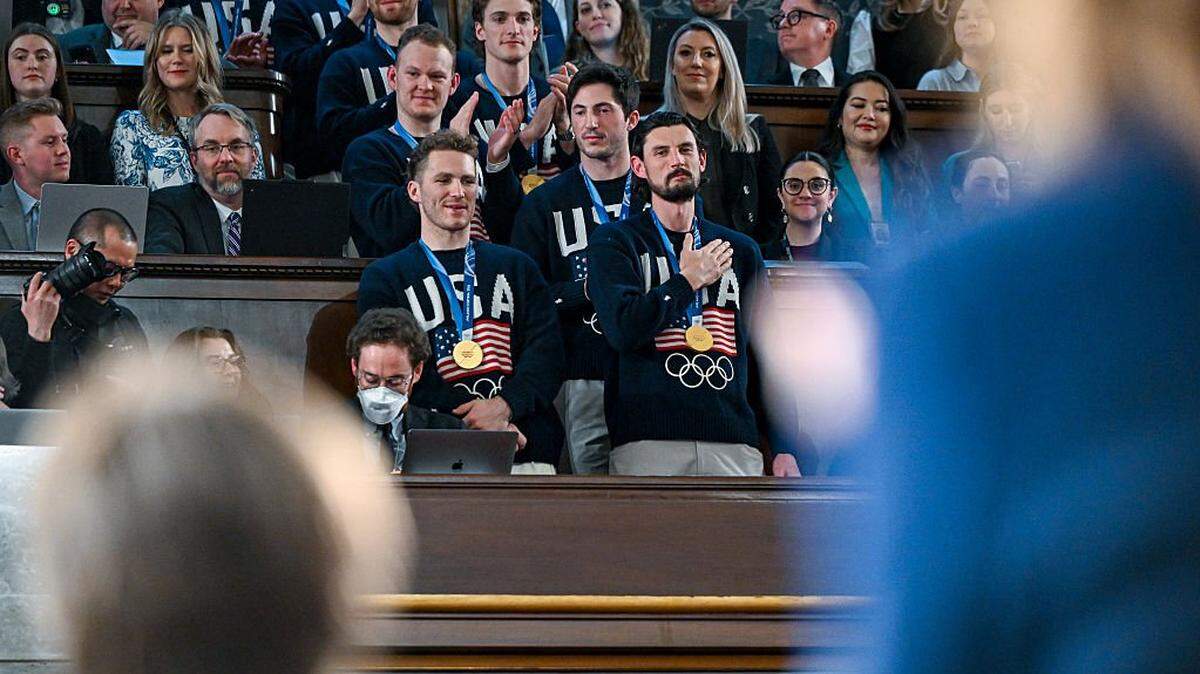 WASHINGTON, DC - FEBRUARY 24:  The U.S. men's Olympic ice hockey team with Matthew Tkachuk and Connor Hellebuyck in front attend President Donald Trump's State of the Union address to a joint session of Congress in the House Chamber at the Capitol on February 24, 2026 in Washington, DC. Behind him are Vice President JD Vance and House Speaker Mike Johnson (R-LA). Trump delivered his address days after the Supreme Court struck down the administration's tariff strategy, and amid a U.S. military buildup in the Persian Gulf threatening Iran. (Photo by Kenny Holston-Pool/Getty Images)