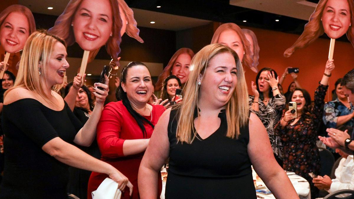 Hialeah Gardens Senior High School teacher Vanessa M. Valle wins 2021 Francisco R. Walker Teacher of the Year. Valle is congratulated by friends and family, many waving “Fathead” placards, as she heads to the stage to receive her award.