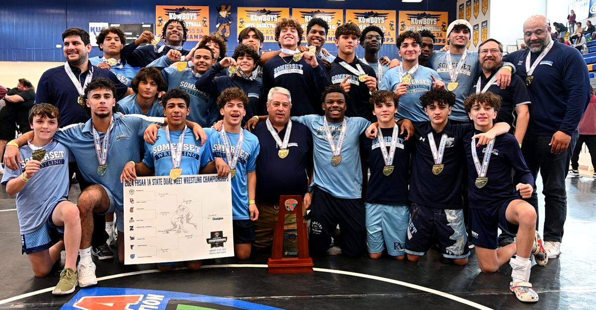Somerset Academy wrestlers and coaches gather with the FHSAA Class 1A Duals State Championship trophy on Saturday at the FHSAA Duals wrestling state championships at Osceola High School in Kissimmee, Fla.