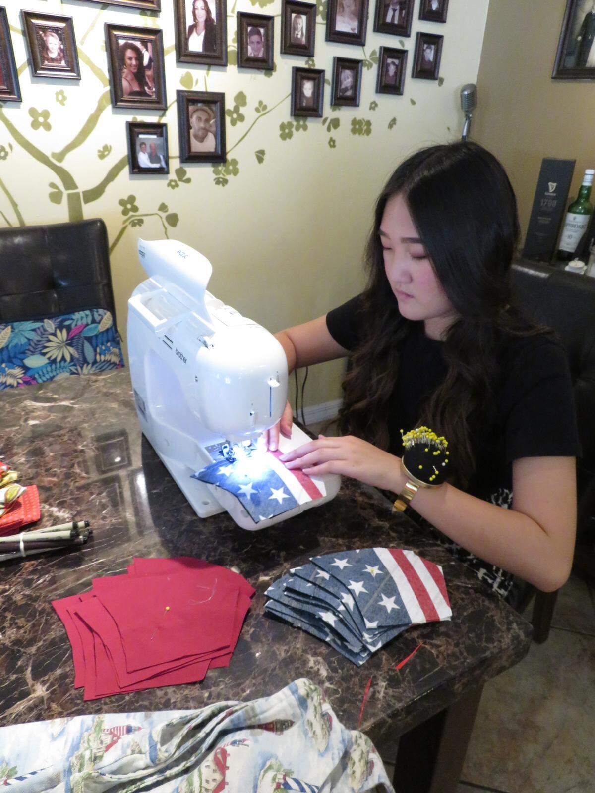 Olivia McAteer, a fashion student at Miami Dade College, sews a mask.