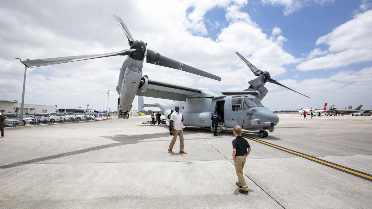 Guests tour the tarmac as they check out military aircraft on display, such as the Boeing V-22 Osprey, during media day for the 2019 Hyundai Air & Sea Show, at the U.S. Coast Guard Air Station Miami in Opa-Locka, Florida, on Friday, May 24, 2019.