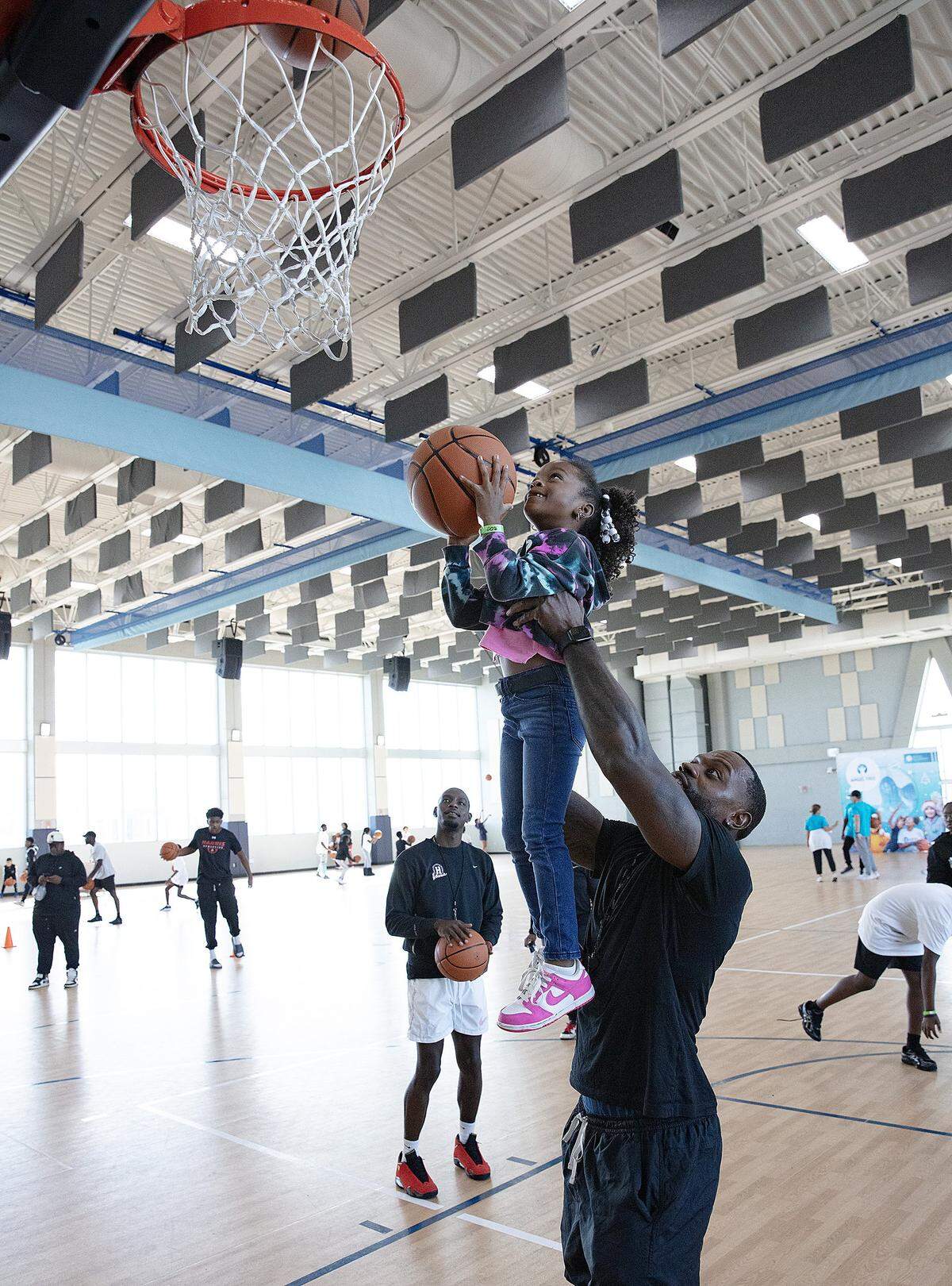Thomas Owens, of Harris Athletics, helps six-year-old Destiny to score during the Prison Fellowship Angel Tree sports camp on Saturday, November 15, 2025 in Miami. Andrew Uloza / for Miami Herald