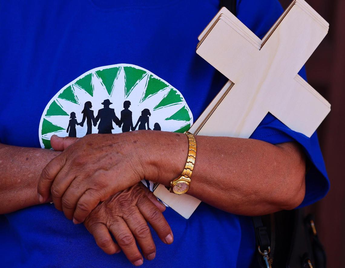 A WeCount! member holds on the several crosses in honor of workers who have died due to extreme heat. About 100 plant nursery workers and families hosted a mass and “Procession for Justice” as they came together to pray for and honor all the workers who have died too soon because of extreme heat at Sacred Heart Catholic Church in Homestead, Florida on Sunday, April 27, 2025.