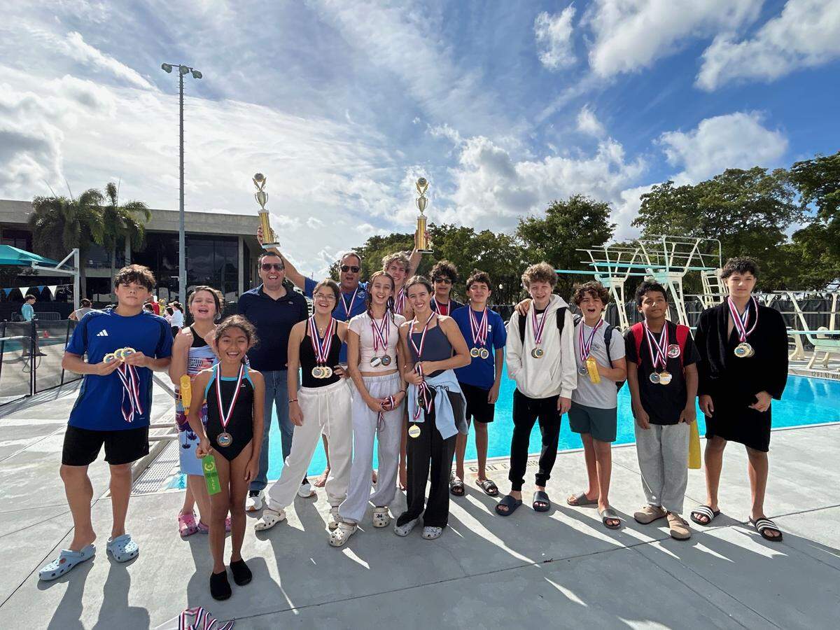 Members of the Miami Beach Nautilus Middle School Sharks swim team celebrated victory in their eighth straight boys and girls county title.