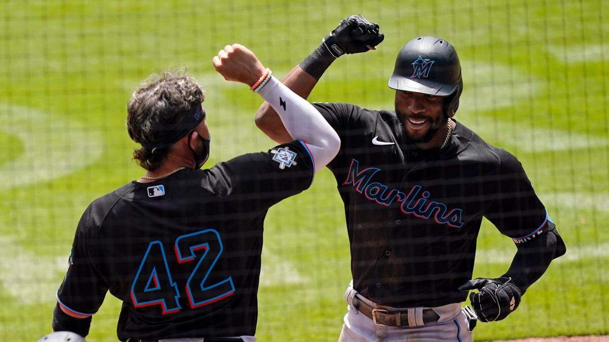 Miami Marlins’ Starling Marte, right, celebrates with Miguel Rojas, left, after hitting a home run in the seventh inning of a baseball game against the Atlanta Braves, Thursday, April 15, 2021, in Atlanta. (AP Photo/Brynn Anderson)
