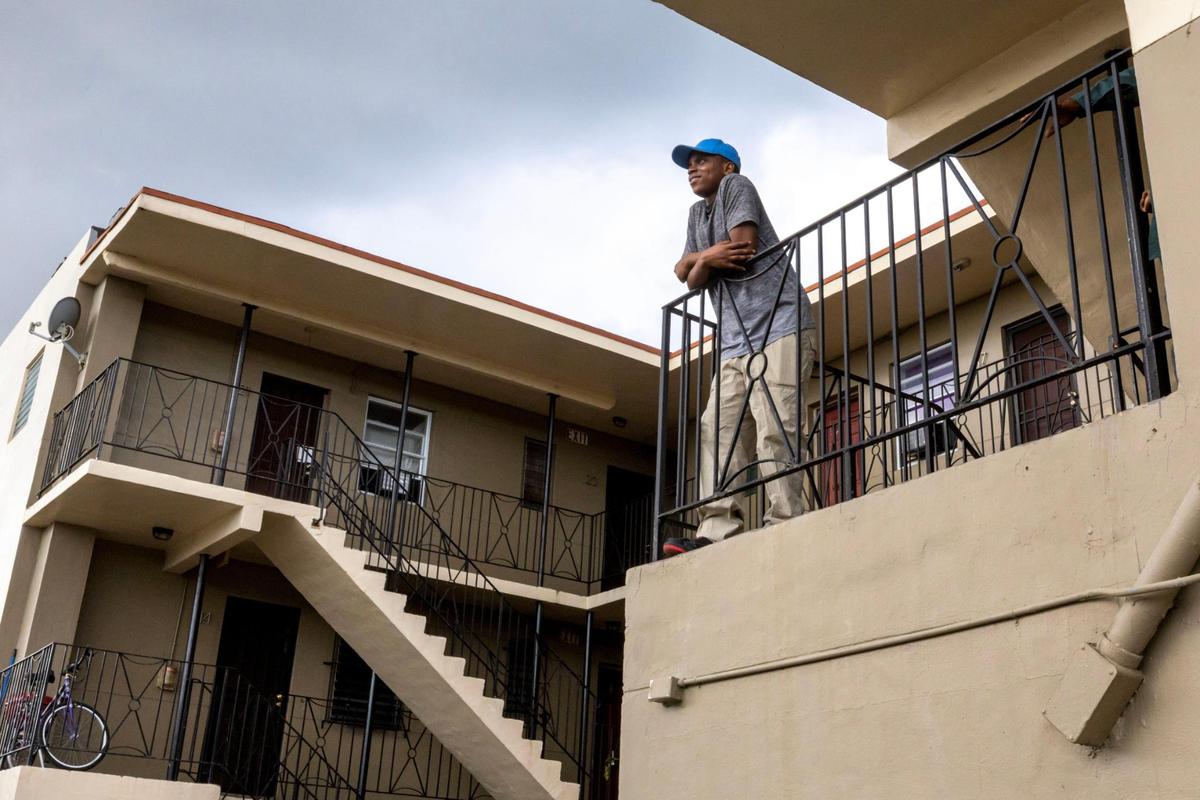Jason Melus contemplates the future as he stands outside the Model City apartment where he lives with his father and sister. This holiday season, their rent has increased and they are looking for an affordable place to live.