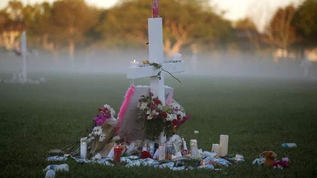 Candles from an evening vigil for victims of the shooting at Marjory Stoneman Douglas High School in February still burn at dawn.