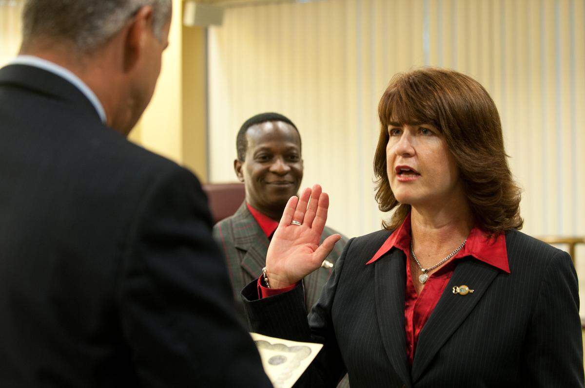 North Miami Beach Mayor George Vallejo, left, swears in Ana Garcia as new city manager as Councilman Frantz Pierre looks on at North Miami Beach City Hall, Tuesday, Aug. 27, 2013. Garcia announced Tuesday she is leaving the job. The terms of her departure were not available.