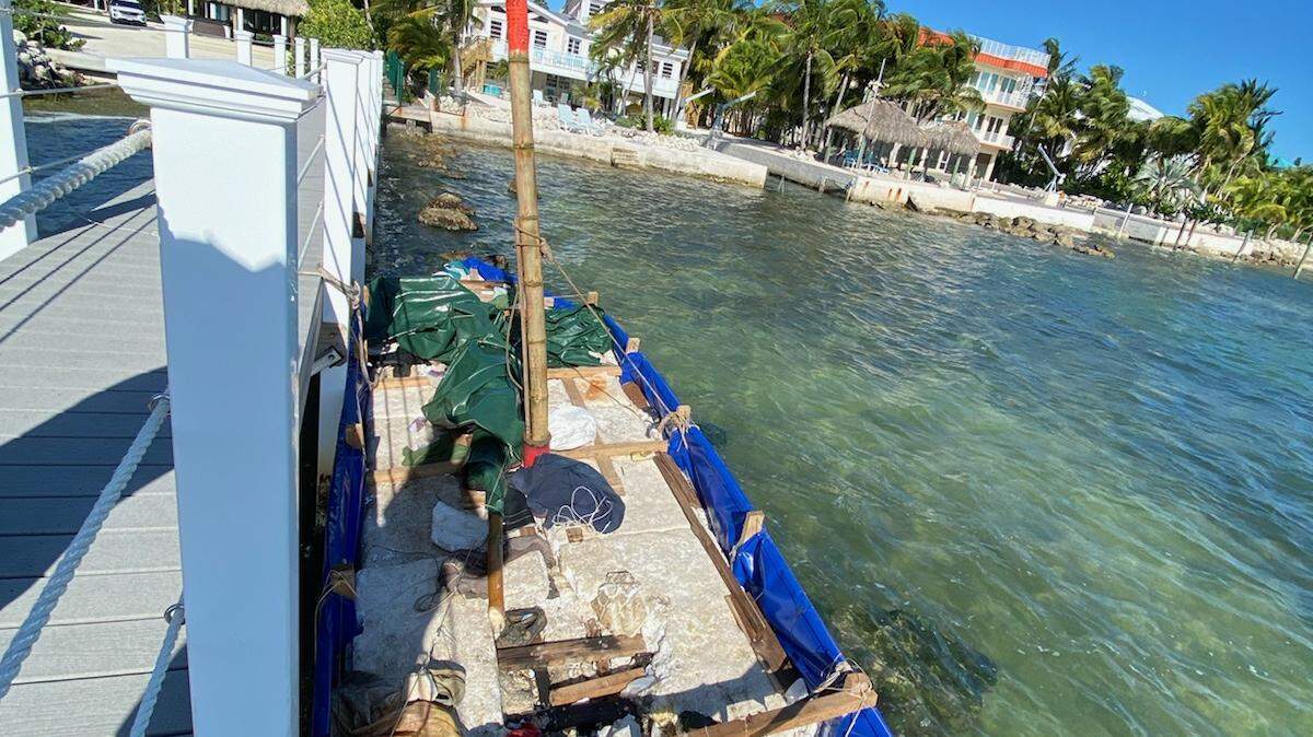 A homemade wooden boat floats by a dock on Summerland Key. A group of 15 migrants from Cuba arrived on the vessel Saturday morning, Dec. 11, 2021.