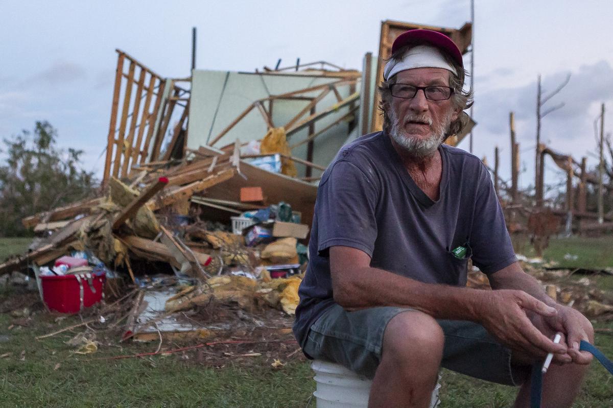 Mickey Fox smokes a cigarette on Oct. 20, 2018, in front of what remains of the trailer in which he and his wife rode out Hurricane Michael in Callaway, Florida. The storm devastated the area, leaving tens of thousands without food, shelter or power.