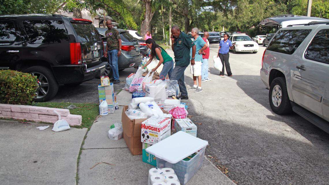 A volunteer fills a box with cans of canned food that will be sent to victims of Hurricane Dorian Tuesday, Sept. 3, 2019 at the headquarters of the Greater St. Paul church in Little Bahama, located in the historic Coconut Grove neighborhood of Miami, Florida.