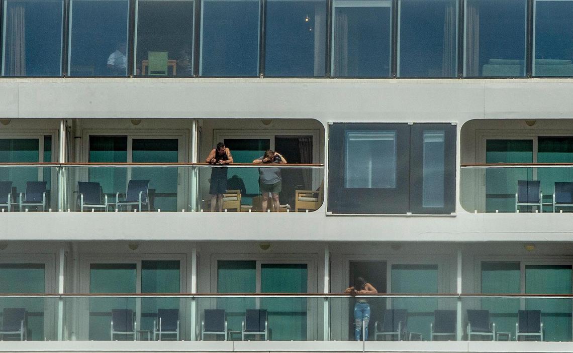 Passengers are seen on the balconies of the Norwegian Cruise Line Pearl as the ship returned early to Port of Miami due to crew members testing positive for COVID-19, on Wednesday, Jan. 5, 2022.