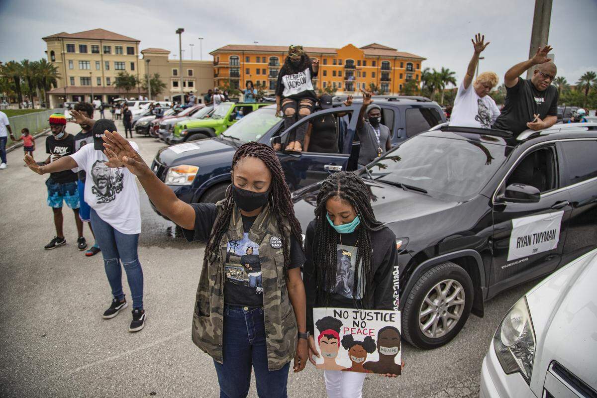 Cousins Nikkie Pryce and Kayla McKenzie, 15, pray with fellow demonstrators at Miramar Town Center after a mock funeral procession in memory of George Floyd and others who have died while in police custody, on Wednesday, June 3, 2020.