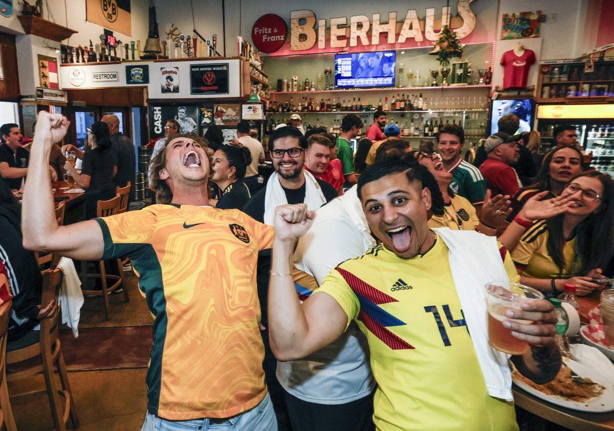 Soccer fans Myles Benham and Morgan Miranda celebrate during a watch party at Fritz & Franz Bierhaus in Coral Gables, Florid a, for the FIFA World Cup Draw on Friday, December 5, 2025.