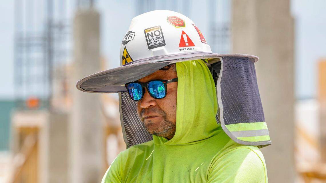 Laborer Elvin Murillo wears protective gear to battle the sun at a residential construction site on Key Biscayne, Florida on Friday, May 17, 2024.