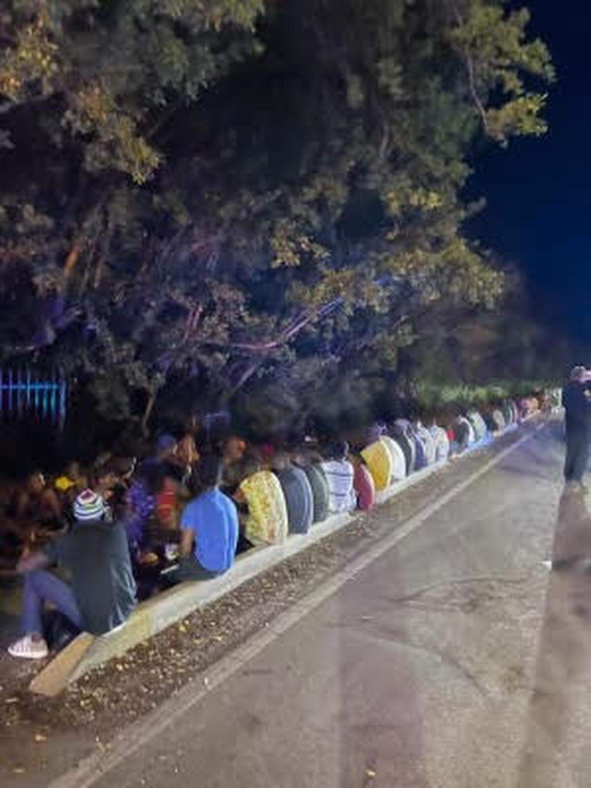 A group of Haitian migrants sits on the side of the road in Key West Wednesday morning, June 26, 2024.