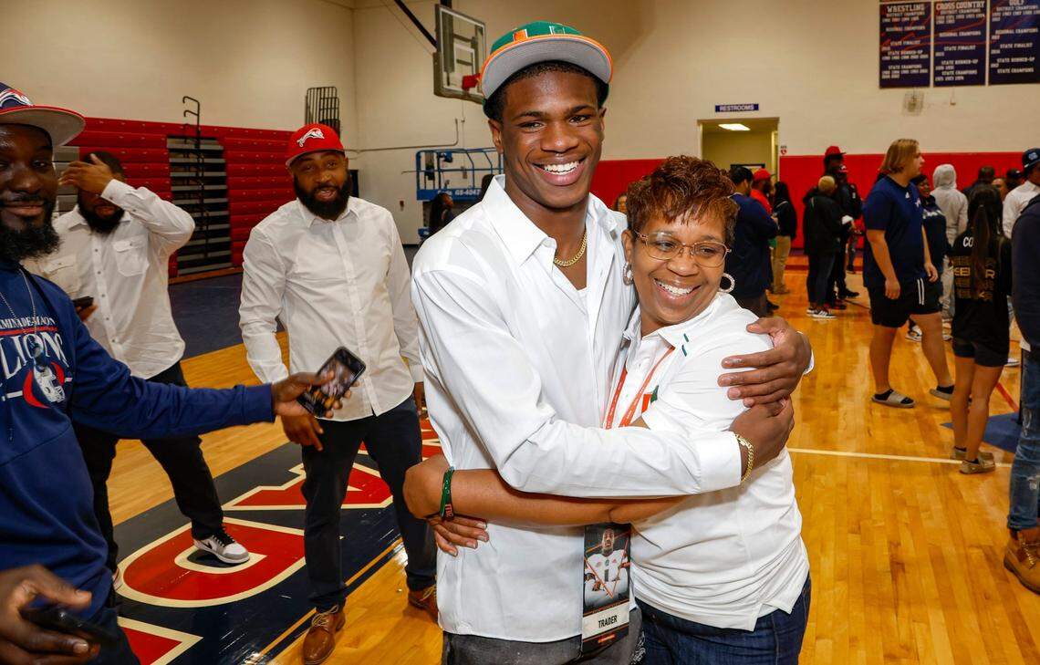 Joshisa Trader hugs his mother Jo Trader after committing to the University of Miami during signing day at Chaminade-Madonna in Hollywood, Florida on Wednesday, December 20, 2023.