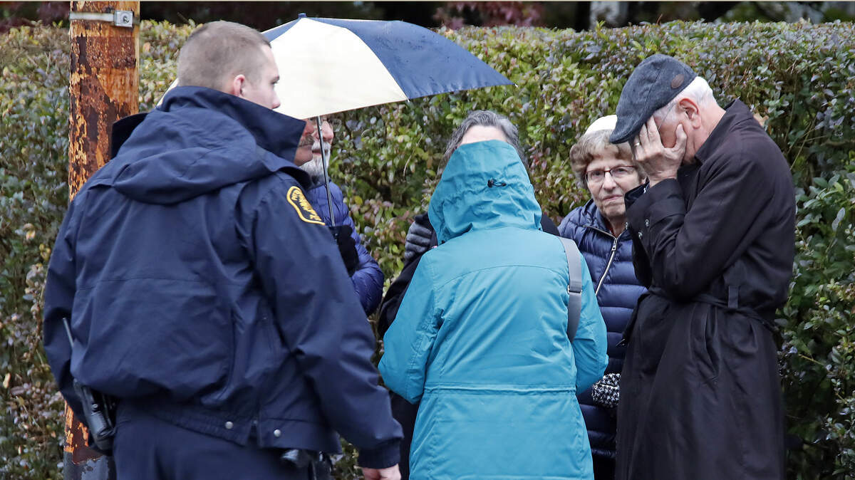 People gather on a corner near the Tree of Life Synagogue in Pittsburgh, Pa., where a shooter opened fire Saturday, Oct. 27, 2018, injuring multiple people.