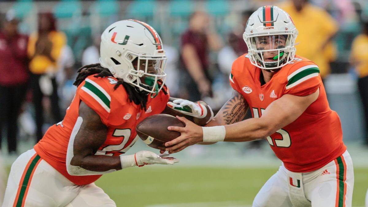 Miami Hurricanes quarterback Jake Garcia (13) hands off to Miami Hurricanes running back Lucious Stanley (24) in the fourth quarter during game against the Bethune Cookman Wildcats at Hard Rock Stadium in Miami Gardens on Saturday, September 3, 2022.