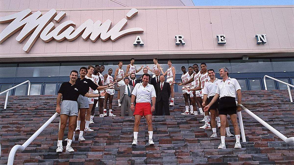 Miami Heat players and assistants frame Coach Ron Rothstein, in the red shorts, at the entrance to Miami Arena.
