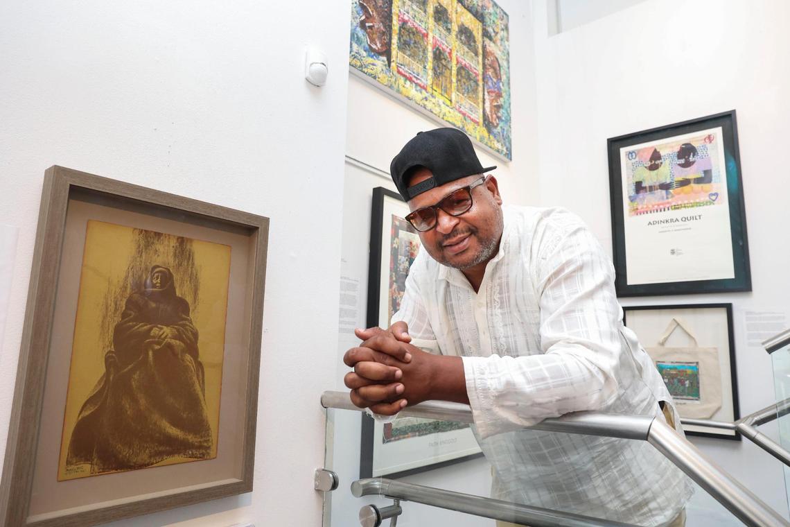 Curator Chris Norwood poses next to a piece by Charles White in Norwood’s gallery, Ward Rooming House in Overtown. “Most of this art is my personal art,” said Norwood. In November, Norwood will be running a show with more of White’s work in collaboration with the University of Miami.