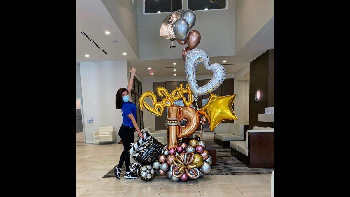 Monica Rodriguez, of Miami Party Balloons, poses in front of one of her creations. She’s feeling the pinch of high helium prices.