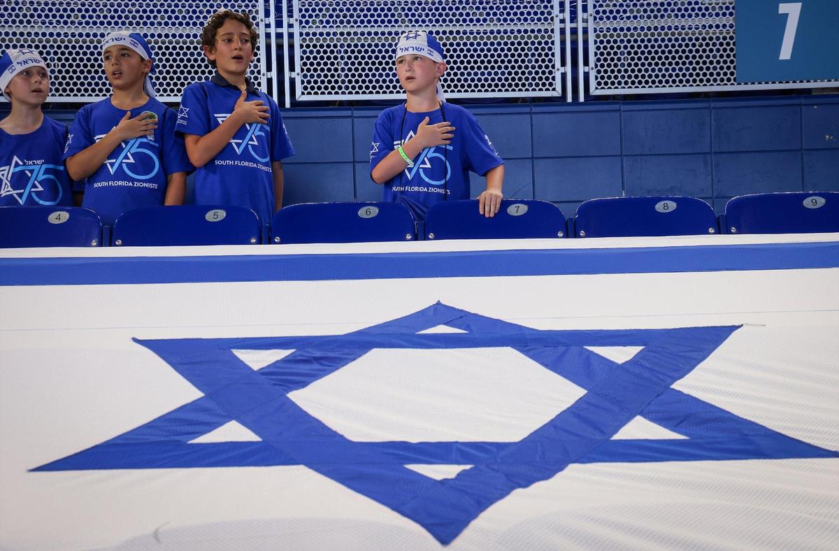 Meir Susterman, 10, in fourth grade , right, stands at attention as the Israeli national anthem is sung as students from Scheck Hillel community School parade to their seats.