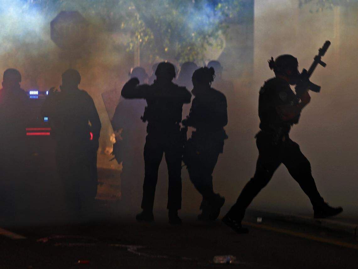 Fort Lauderdale police move through the fog of tear gas as they try to disperse protesters at the municipal garage in downtown Fort Lauderdale near Wayne Huizenga Park. The rally and march on Sunday, May 31, 2020, were among demonstrations around the country in reaction to the death of George Floyd, an unarmed black man who died in police custody on May 25 after a Minneapolis police officer drove a knee into his neck.