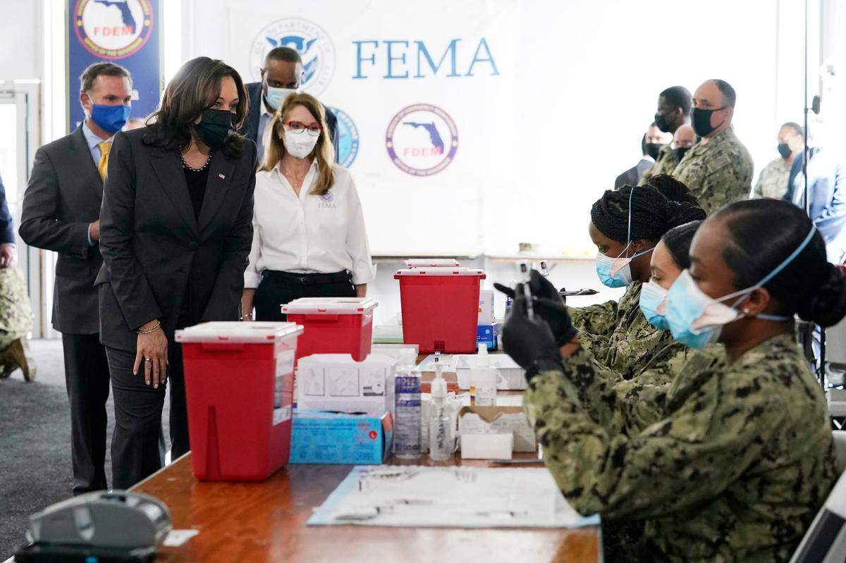 Vice President Kamala Harris, left, receives a tour from FEMA regional administrator Gracie Szchech, as members of the Navy, seated right, prepare Pfizer vaccines at the Jacksonville Community Vaccination Center, Monday March 22, 2021, in Jacksonville, Fla. Also present: Jacksonville Mayor Lenny Curry, left, and Rep. Al Lawson, D-Fla., third from left.
