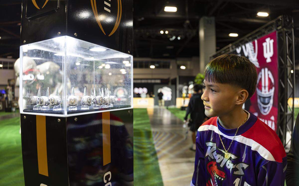 Jordan Laguana, 12, looks at championship rings while visiting the Playoff Fan Central at the Miami Beach Convention Center on Friday, Jan. 16, 2025, in Miami Beach, Fla. Fans can visit the event ahead of the College Football Playoff National Championship Game between the Miami Hurricanes and the Indiana Hoosiers and enjoy a variety of family-friendly interactive experiences.
