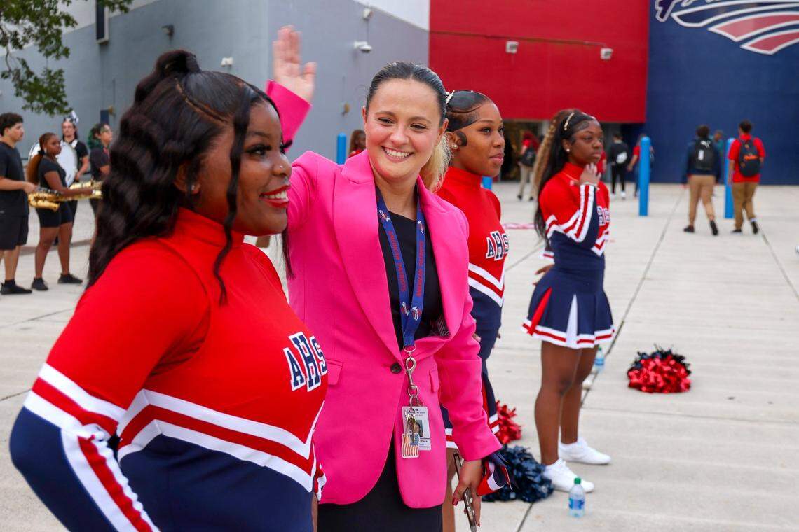 Chelsea Torres, in the pink jacket, tries to cool off cheerleaders as they greeted American High School students on the first day of the school year on Thursday, Aug. 17, 2023., for Miami-Dade Public Schools.