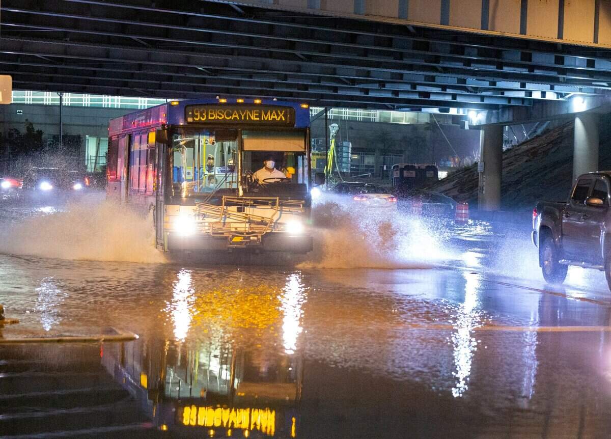 Cars drive through a flooded Biscayne Boulevard under the 395 expressway in downtown Miami on Tuesday, February 16, 2021.