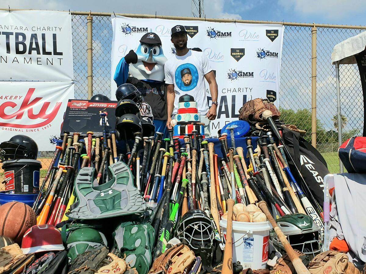 Miami Marlins pitcher Sandy Alcantara (right) poses with Billy the Marlin in front of the baseball equipment donated as part of his charity softball tournament at Bucky Dent Park in Hialeah on Saturday, Sept. 7, 2019.