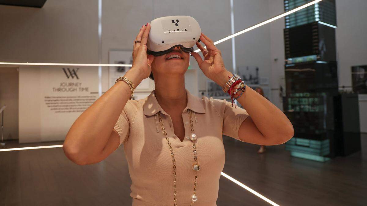 Alejandra Castillo, vice president of sales for PMG Residential, uses a virtual reality headset on Aug. 9, 2023, as she walks around the property at the Waldorf Astoria 100-story condo tower and hotel as it’s being built in downtown Miami.