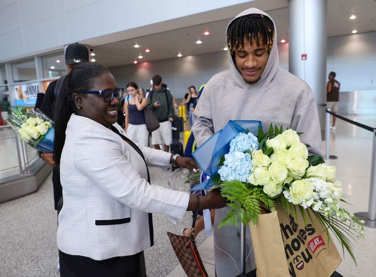 Consul Mona Nelson of the Consulate General of Haiti in Miami presents flowers to Haiti national team player Martin Expérience upon his arrival at Miami International Airport from Paris on Saturday, July 4, 2026. The welcoming ceremony preceded the team’s departure to Haiti the following day.